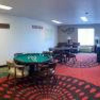 A room with a poker table and chairs set up for gaming.