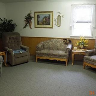 A cozy living room with a sofa, two chairs, and decorative elements on the wall.