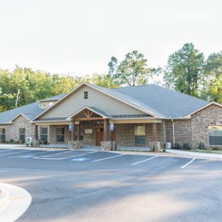 An exterior view of a healthcare facility, surrounded by lush greenery.