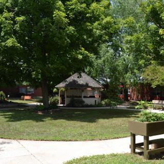 A serene park setting featuring a gazebo surrounded by lush greenery.