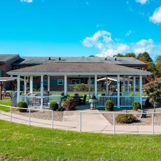 A beautiful outdoor pavilion surrounded by well-maintained gardens under a clear blue sky.