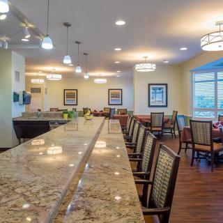 A modern kitchen and dining area with a long countertop and comfortable seating.