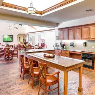 A spacious and modern kitchen with an adjacent dining area featuring wooden furniture.
