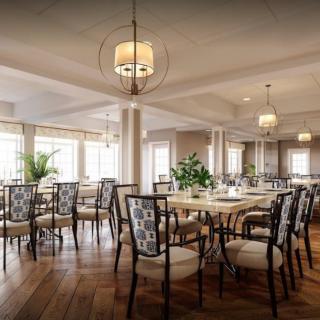 A beautifully decorated dining room with elegant tables and chairs, accentuated by warm lighting and greenery.