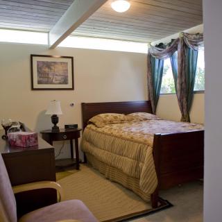 A cozy bedroom with a bed, side tables, and a window with curtains.
