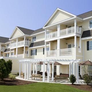 Modern apartment building with balconies and outdoor seating area.