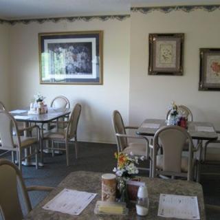 A cozy restaurant dining area with neatly arranged tables and chairs, featuring wall decorations.