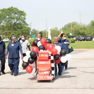 A vibrant community parade featuring participants carrying balloons and celebrating together.