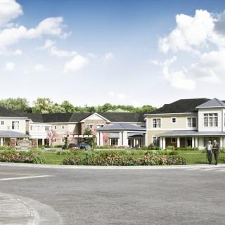 An architectural rendering of a modern suburban residential complex with landscaped grounds and a clear sky.