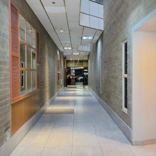 A modern, well-lit hallway featuring sleek walls and flooring.