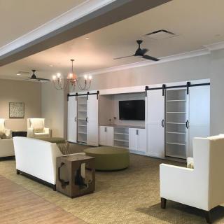 A modern living room with sleek furniture, a television, and stylish barn door cabinets.