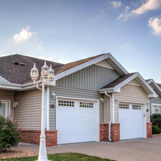 Suburban houses with garages and a lamp post lining the driveway.