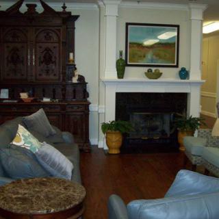A cozy living room with a fireplace, comfortable seating, and elegant decor.