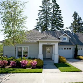 A suburban house with a well-maintained garden and driveway.