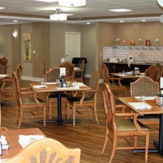 An empty restaurant dining area with neatly arranged tables and chairs.