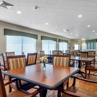 A spacious and well-lit dining room with multiple tables and chairs arranged neatly.