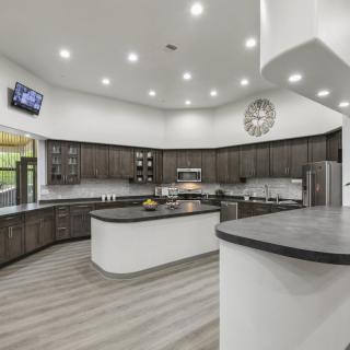 A spacious, modern kitchen with a central island and sleek design elements.