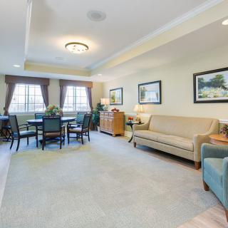 A spacious living room featuring a comfortable sofa, dining area, and elegant decor.