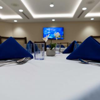 Elegant dining setup with blue napkins and modern lighting.