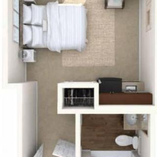A compact bedroom floor plan featuring a bed, storage, and bathroom.