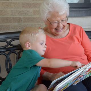 A grandmother and child enjoying a book together.