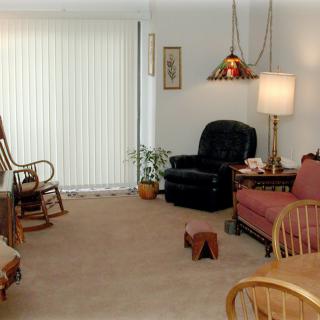 Cozy living room with a mix of seating options and a soft lamp glow.
