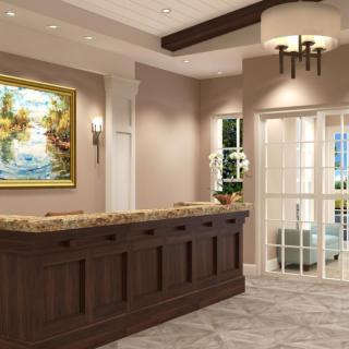 A modern reception area with a wooden desk, elegant lighting, and framed artwork.
