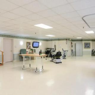 A spacious hospital rehabilitation room equipped with exercise machines.