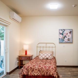 A cozy bedroom with a single bed, bedside table, and wall decor.