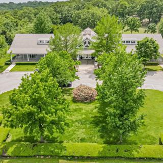 Aerial view of a building surrounded by lush greenery and trees.