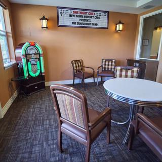 A cozy lounge area with a jukebox and comfortable seating.