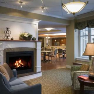 A cozy living room with a fireplace and comfortable seating, elegantly decorated in warm tones.