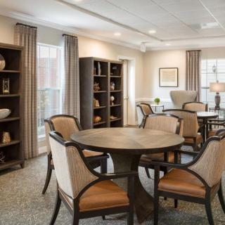 A cozy living and dining area featuring elegant furniture and bookshelves.
