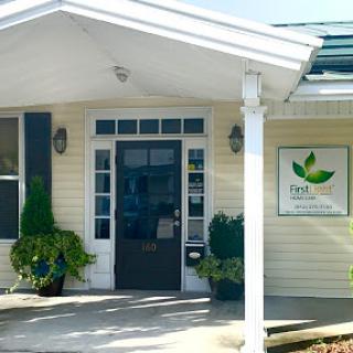 A welcoming entrance to a facility with green landscaping.