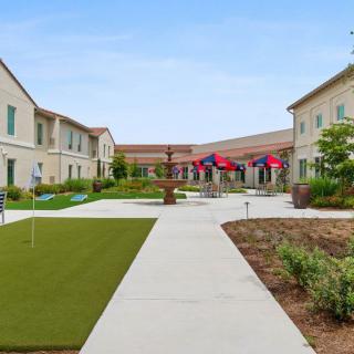 A landscaped courtyard surrounded by buildings with flags displayed along the pathway.