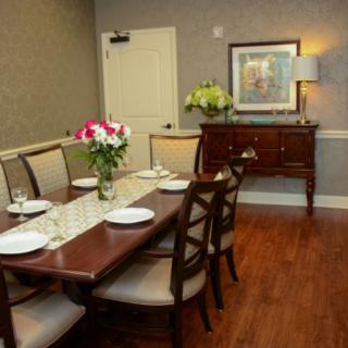 A well-decorated dining room featuring a wooden table set with plates and flowers.