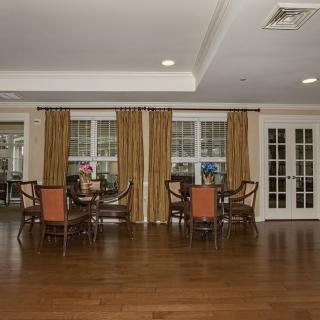 Spacious dining area with hardwood flooring and elegant curtains.