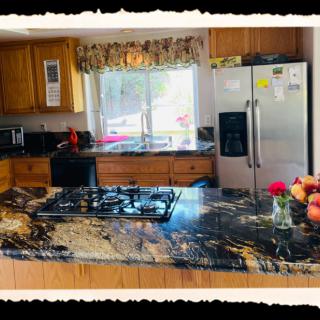 A modern kitchen with a granite countertop and various appliances.