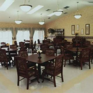 A spacious dining area with multiple tables and chairs, well-lit by ceiling lights.