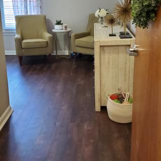 A cozy waiting room with armchairs, a small table, and decorative elements.