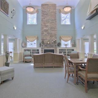A spacious living room with high ceilings, featuring a central fireplace and ample seating.
