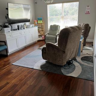 Cozy living room with chairs, a TV, and a large window.