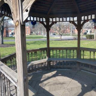 A peaceful gazebo surrounded by green grass, perfect for relaxation in the park.