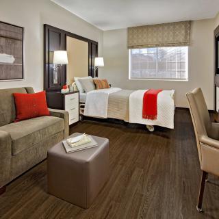 A modern and cozy bedroom with a comfortable bed, a sofa, and elegant decor.