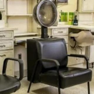 A salon interior featuring a hair drying chair and equipment.