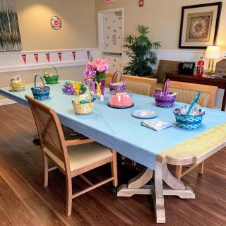 A dining room table set with colorful baskets and decorations, ready for a festive gathering.