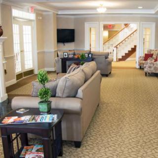 A cozy living room with sofas, a television, and a staircase in the background.