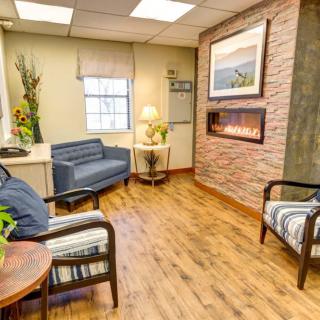 A cozy waiting room with comfortable seating and a warm fireplace.