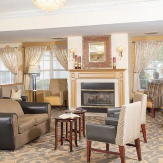 A cozy living room interior with a fireplace, comfortable seating arrangement, and elegant decor.