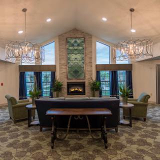 A spacious and modern lobby featuring comfortable seating, a fireplace, and elegant chandeliers.
